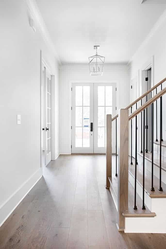 Hallway and staircase featuring matte finish custom wide plank hardwood flooring by Textures Nashville