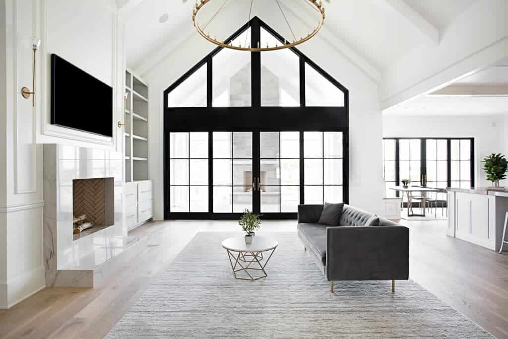 Modern Farmhouse living room featuring large black framed windows and matte finish wide plank hardwood flooring by Textures Nashville