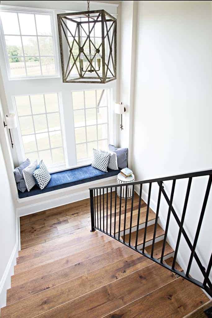 Staircase in a modern french country home featuring wide plan neutral brown hardwood flooring by Textures Nashville.
