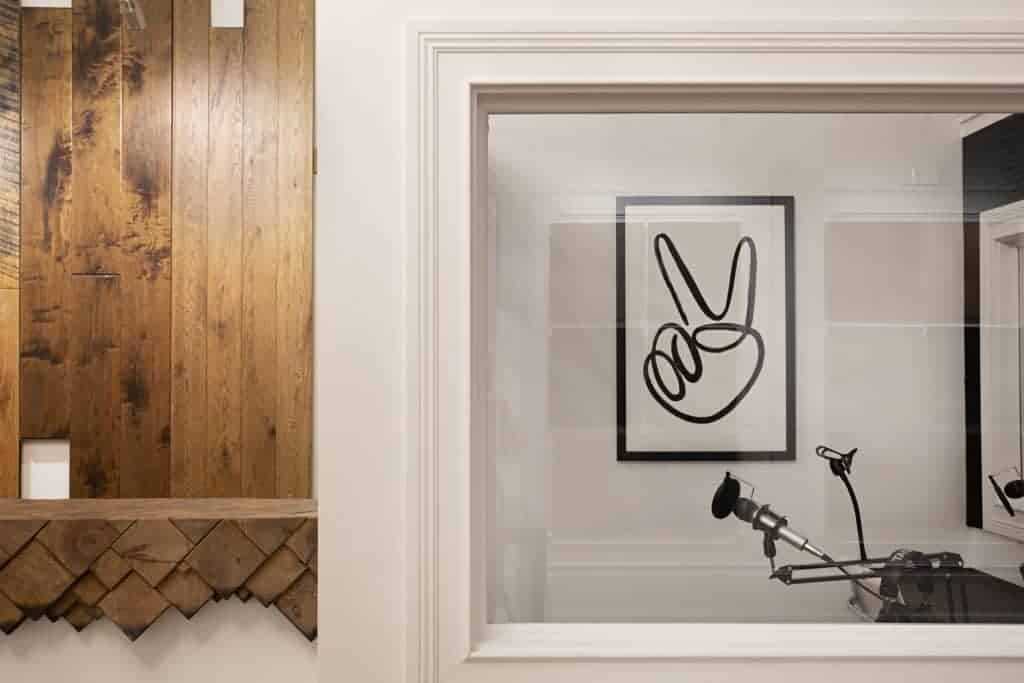 A picture frame filled with art hangs on the wall of a cozy indoor room.