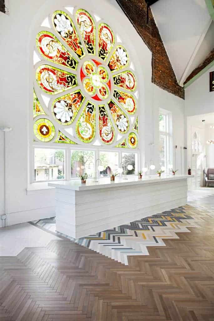 A modern interior design featuring art on the walls, tiled floors, and a detailed ceiling is showcased in the building's house room.
