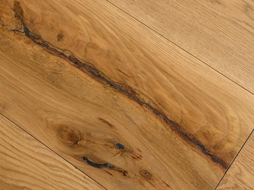 This is an image showing a close-up of a wooden floor with a distinctive dark grain pattern and knots, displaying natural wood textural beauty.